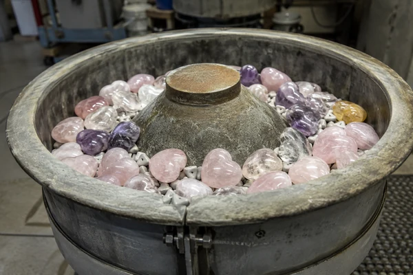Crystal hearts being polished in a large vibratory tumbler, the final step to make crystal carvings shine.
