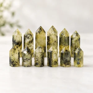 Wholesale yellow-green crystal point towers arranged in a clean product photography scene on a light neutral background.