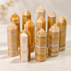 Warm golden crystal towers arranged together in a clean light tabletop product photography scene.