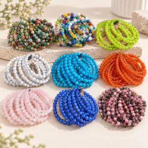Assorted colorful natural stone beaded bracelets displayed on a light neutral tabletop