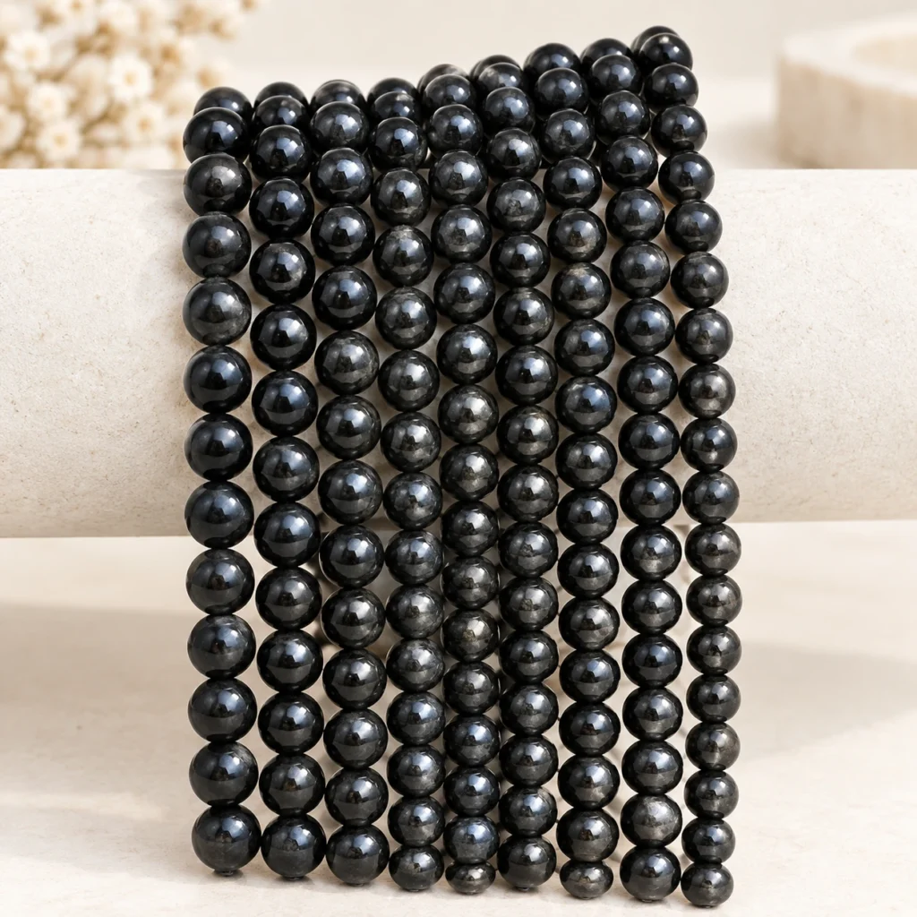 Black obsidian bead strands draped on a neutral display form