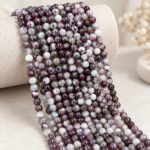 Wholesale Pink Tourmaline 4mm round bracelet bead strands displayed on a light minimalist tabletop.
