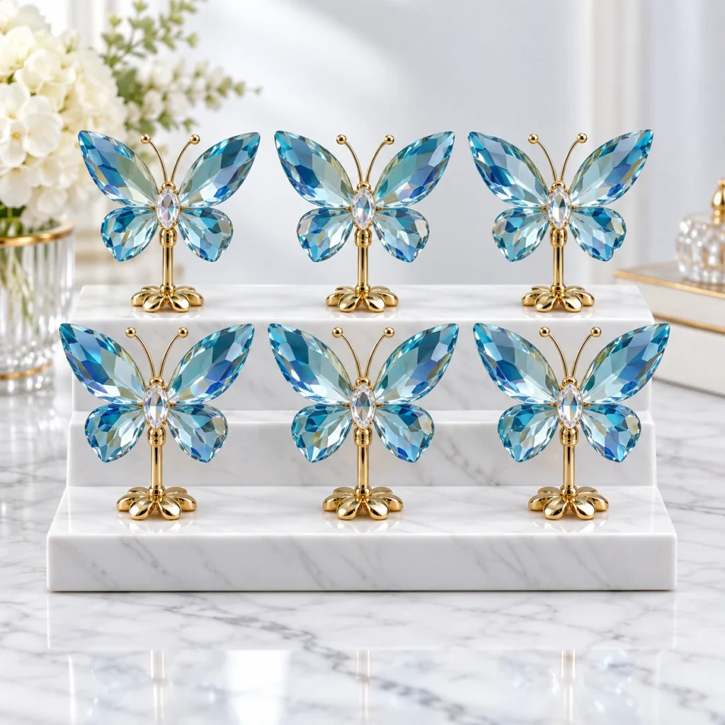 Blue crystal butterfly ornaments with gold stands displayed on a three-tier marble platform.