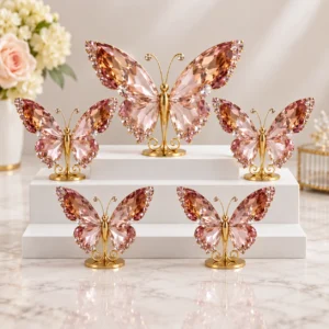 Luxury pink crystal butterfly ornaments with gold stands arranged on a white tiered display.