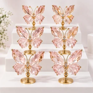 Pink crystal butterfly ornaments displayed on a layered stand with gold-tone bases