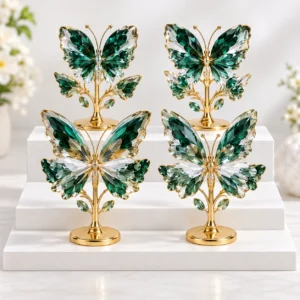 Green crystal butterfly ornaments with gold-tone stands displayed on a tabletop