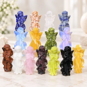 assorted natural crystal angel carvings in multiple polished stone colors on a light minimalist tabletop