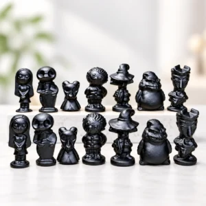 assorted black obsidian Halloween character crystal carvings displayed on a light minimalist tabletop