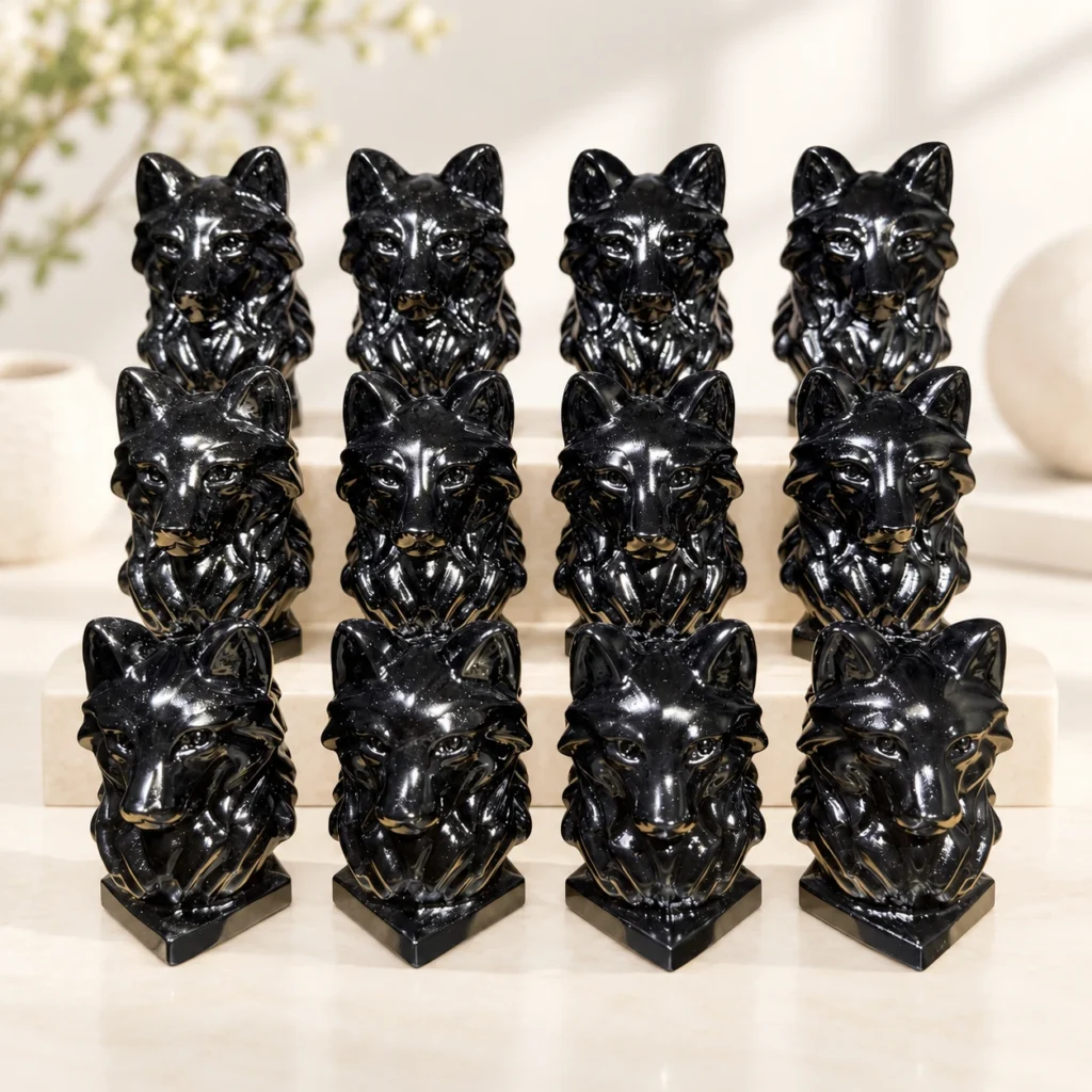 polished black obsidian wolf head crystal carvings arranged on a light minimalist tabletop