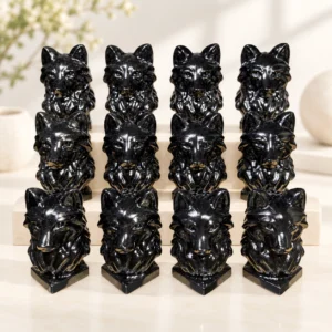 polished black obsidian wolf head crystal carvings arranged on a light minimalist tabletop