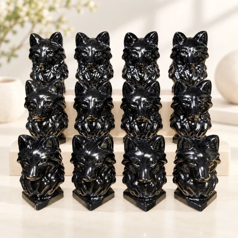 polished black obsidian wolf head crystal carvings arranged on a light minimalist tabletop