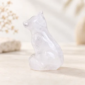 clear quartz wolf dog crystal carving with translucent natural inclusions on a light minimalist tabletop