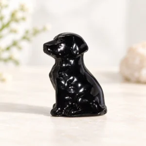polished dark natural crystal dog carving centered on a light minimalist tabletop