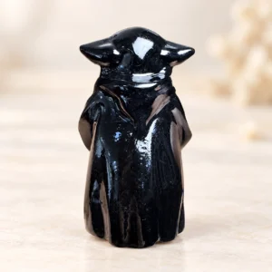 Glossy black fantasy wise master crystal carving centered on a light minimalist tabletop