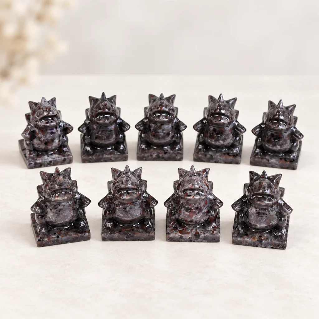 Fire quartz fantasy monster character crystal carvings arranged in rows on a light minimalist tabletop
