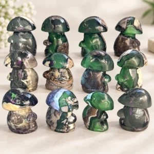 Mixed fire quartz mushroom crystal carvings with green and dark natural stone patterns on a light tabletop