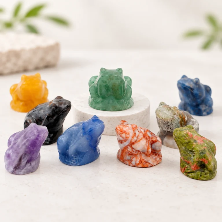 Assorted natural crystal frog carvings in multiple colors arranged on a light minimalist tabletop
