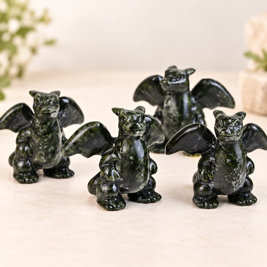Green jade fire dragon monster crystal carvings with spread wings on a light minimalist tabletop