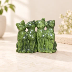 Green natural stone kissing cat crystal carving on a light minimalist tabletop