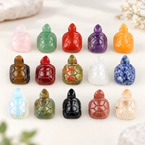 Assorted mini turtle crystal carvings in multiple natural stone colors on a light minimalist tabletop