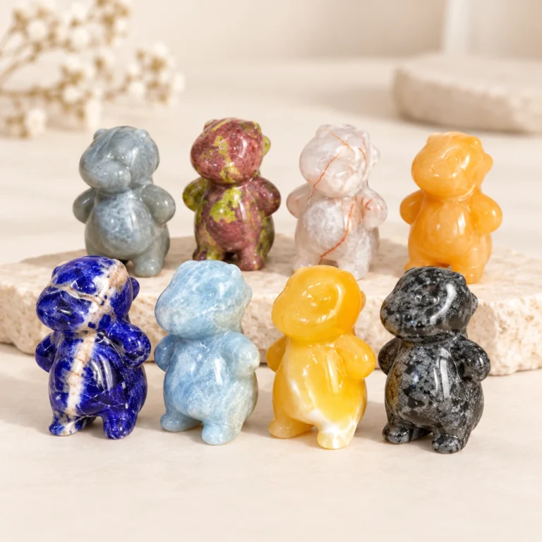 Assorted mixed material chubby dragon crystal carvings in multiple natural stone colors on a light minimalist tabletop
