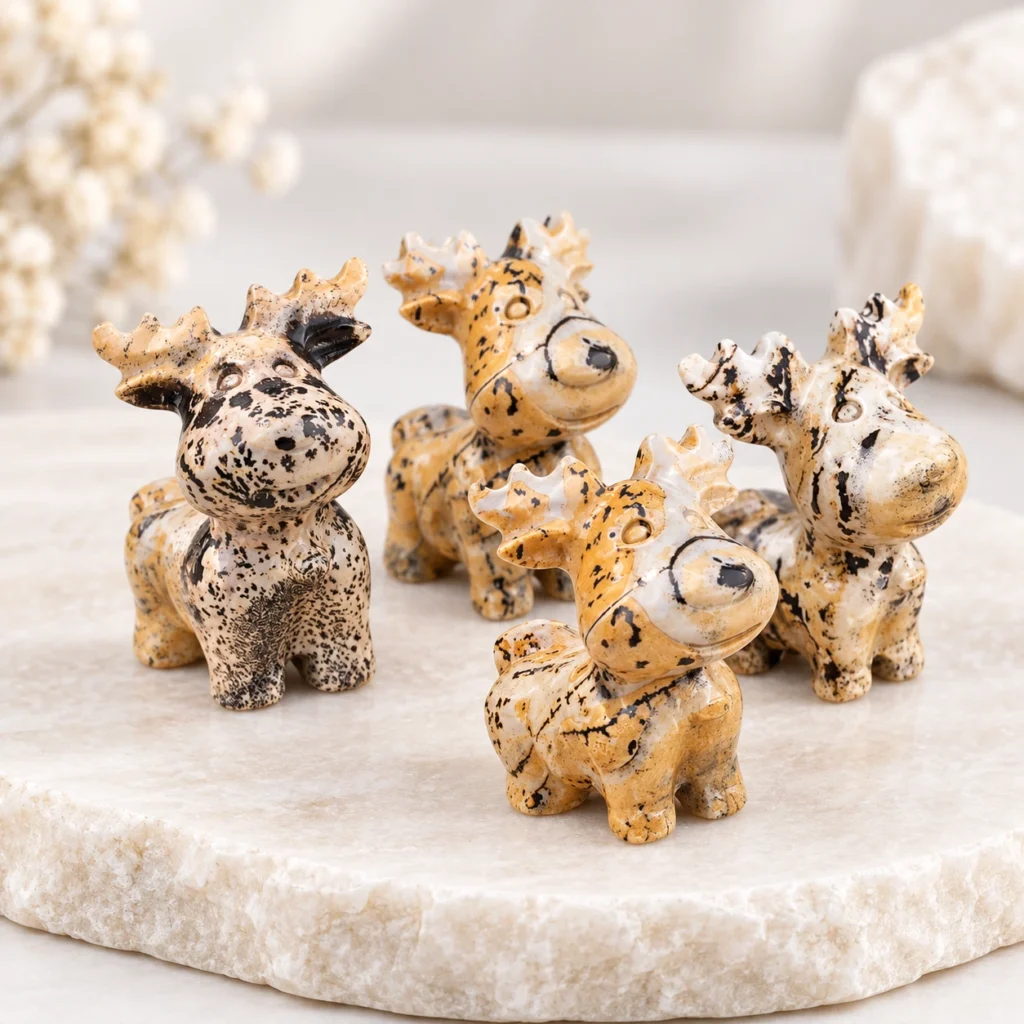 Picture jasper deer crystal carvings with tan cream and black natural patterns on a light tabletop