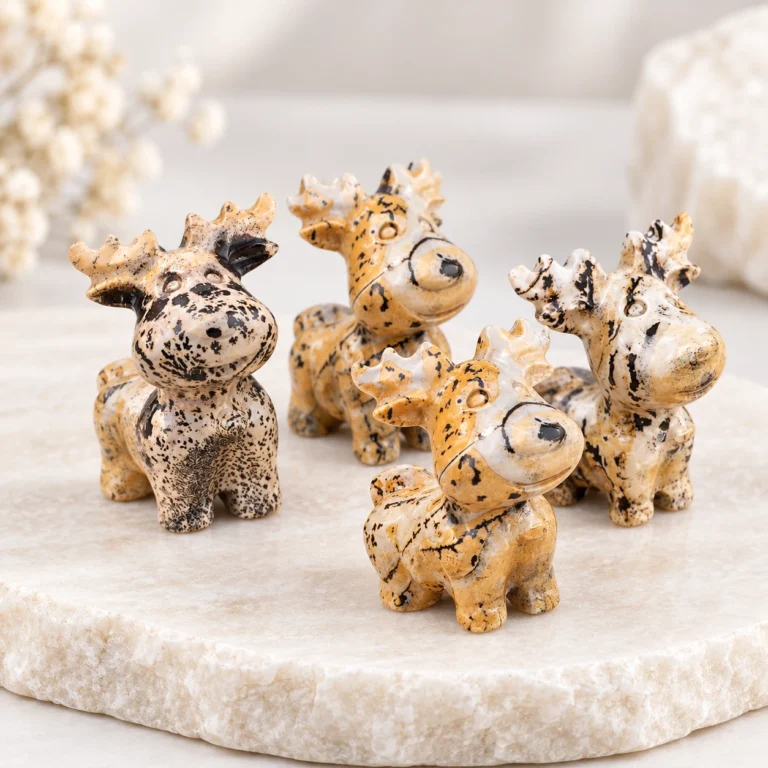 Picture jasper deer crystal carvings with tan cream and black natural patterns on a light tabletop