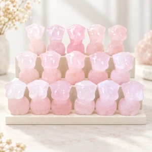 Rose quartz female torso crystal carvings arranged on pale stepped risers in a light minimalist scene